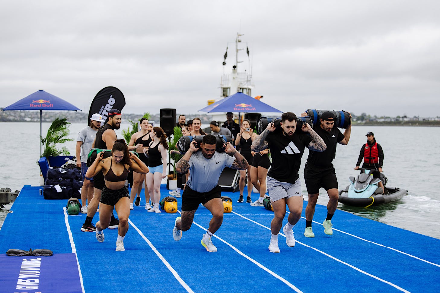 Four fitness influencers tackle weighted lunges at a hyrox-inspired workout.